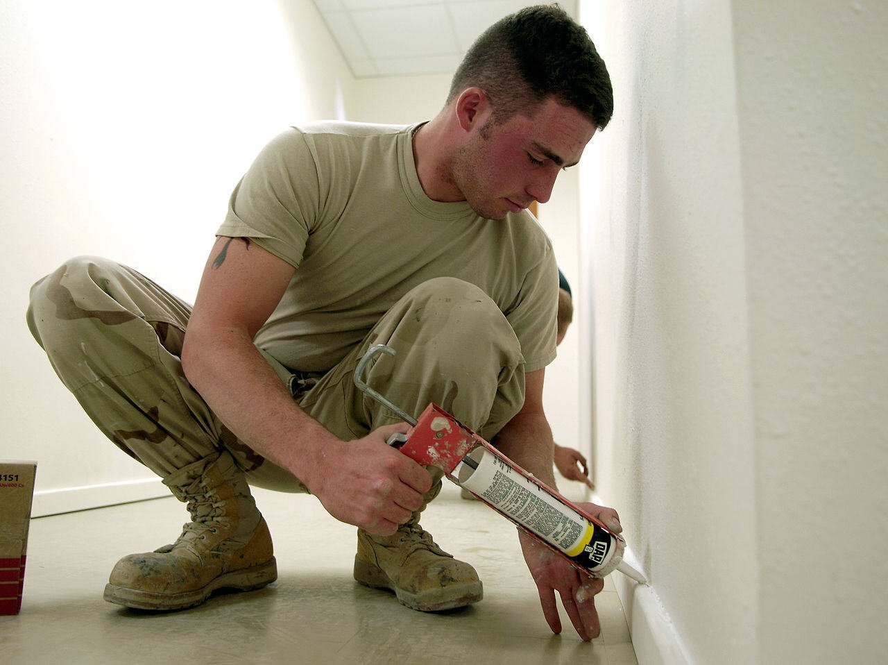 man caulking his floor trim