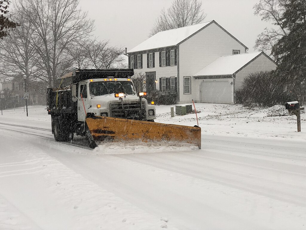 snow plow clearing a neighborhood street