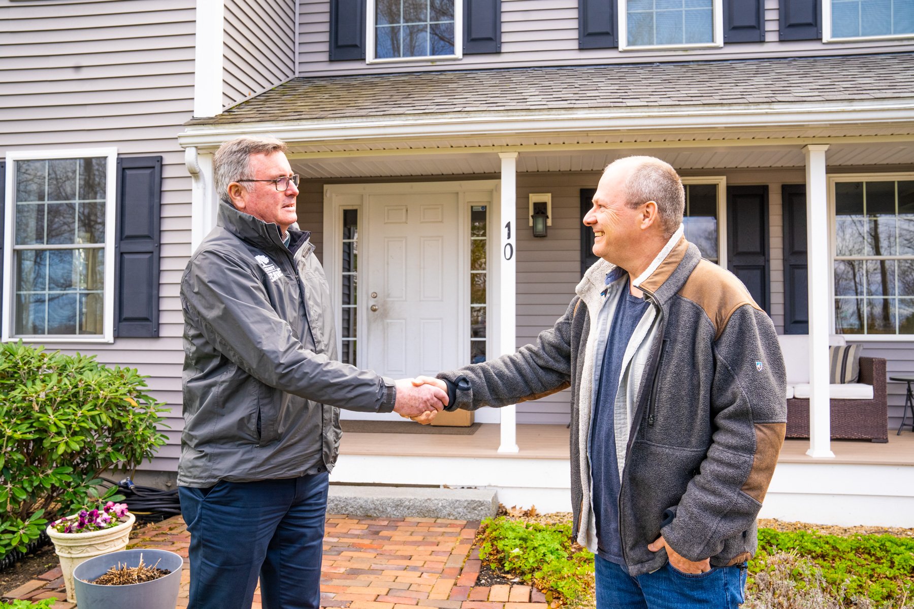 homeowner shakes hands with pest control expert