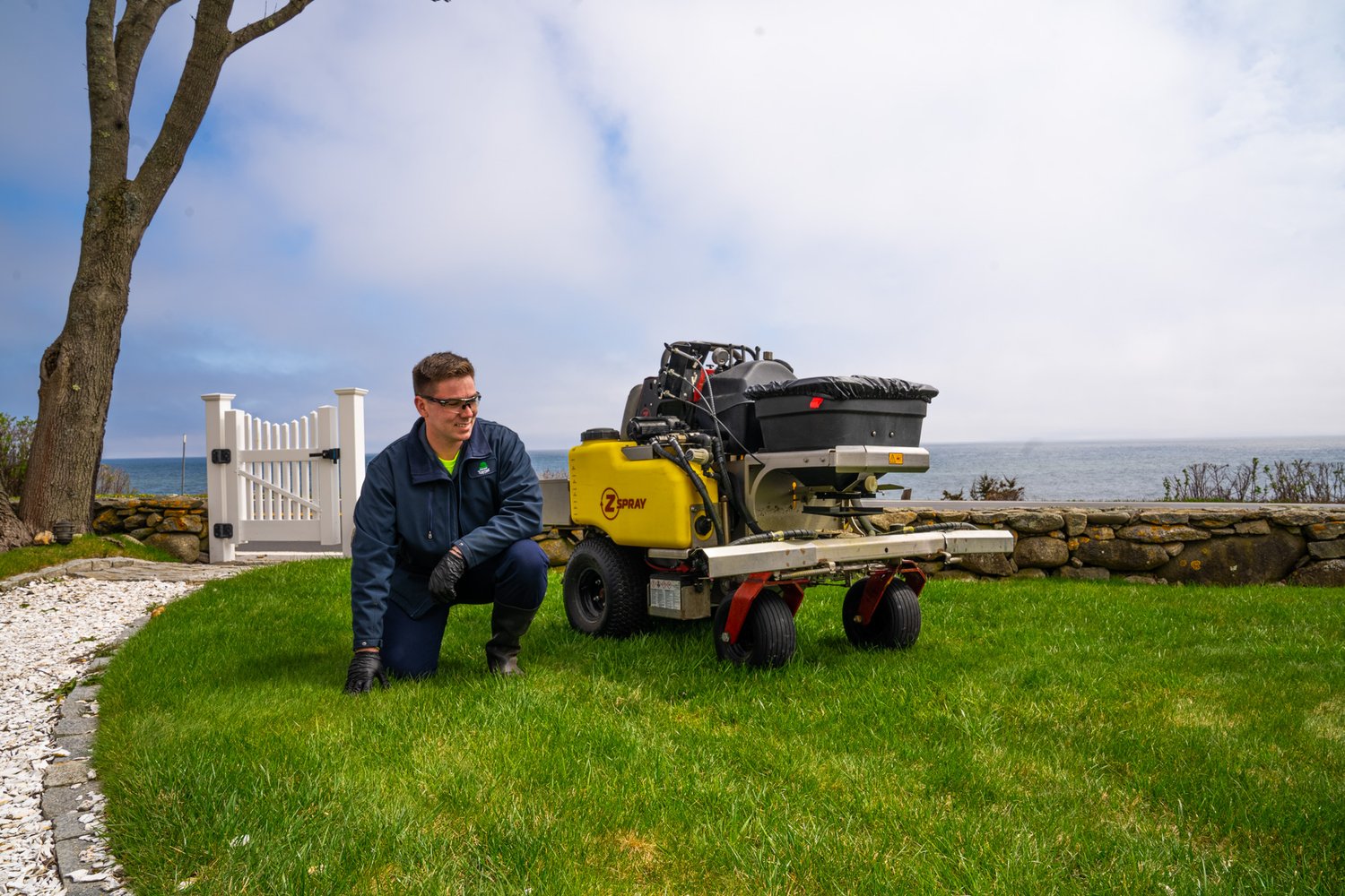 lawn care technician inspecting green lawn