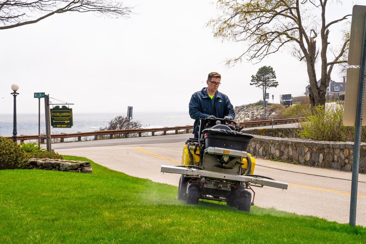 lawn care technician sprays grass with fungicide
