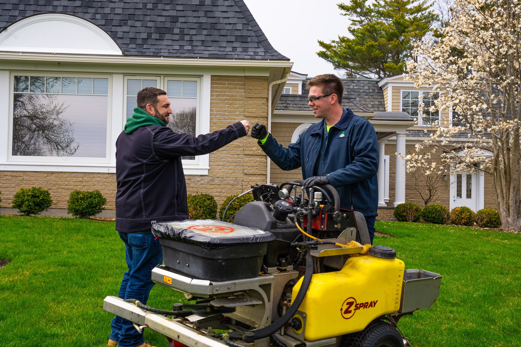 lawn care technician and manager celebrating healthy grass