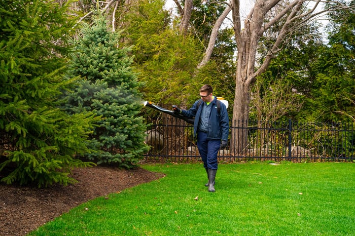 pest mosquito control technician spraying shrubs