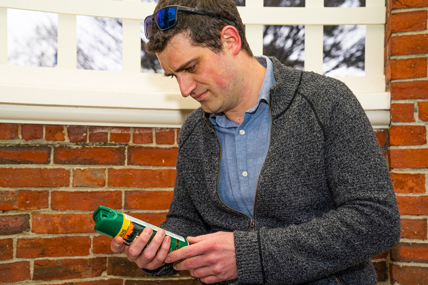 homeowner inspecting a bottle of store-bought mosquito spray