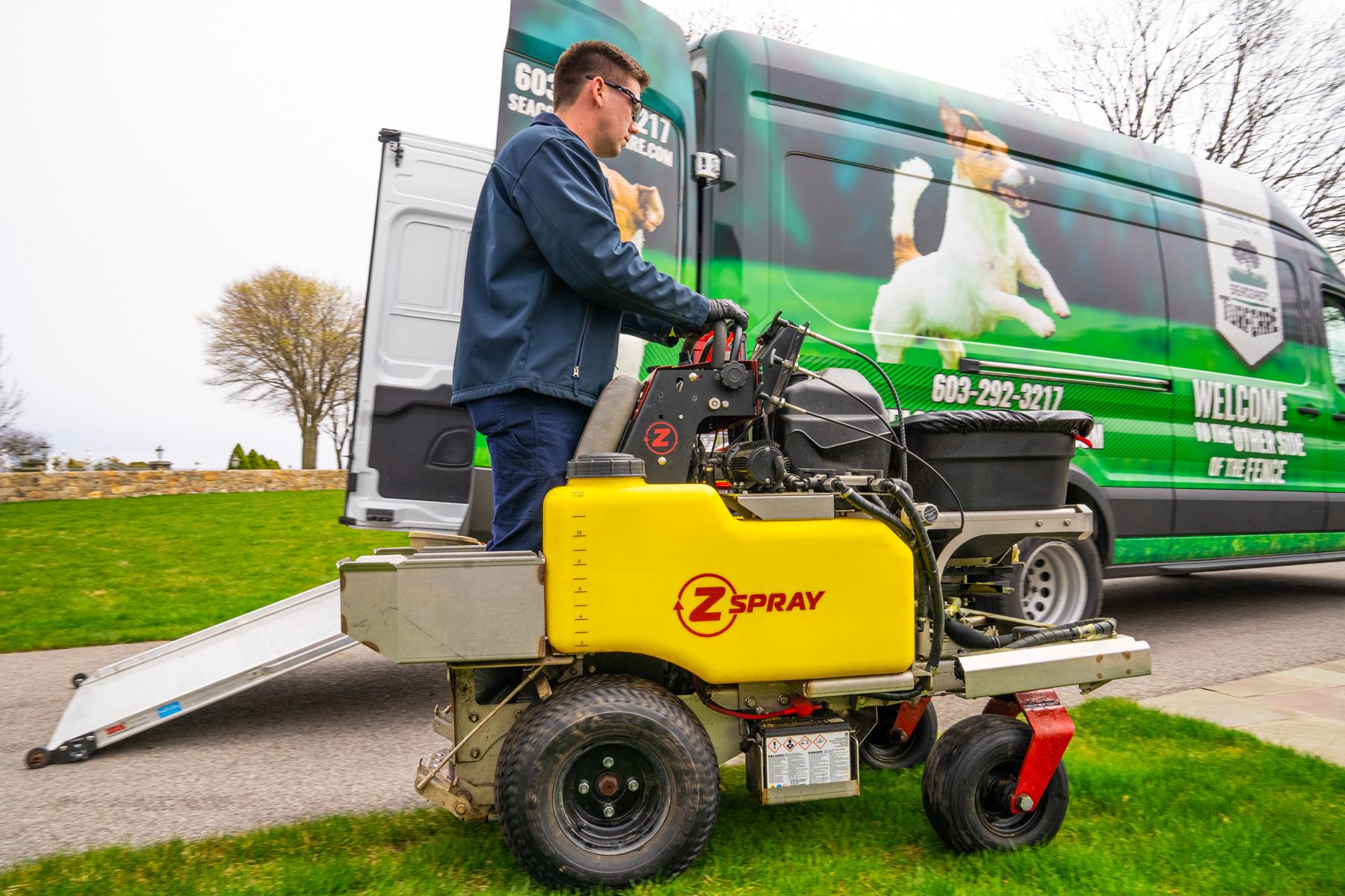 lawn care technician pulls fertilization sprayer out of van