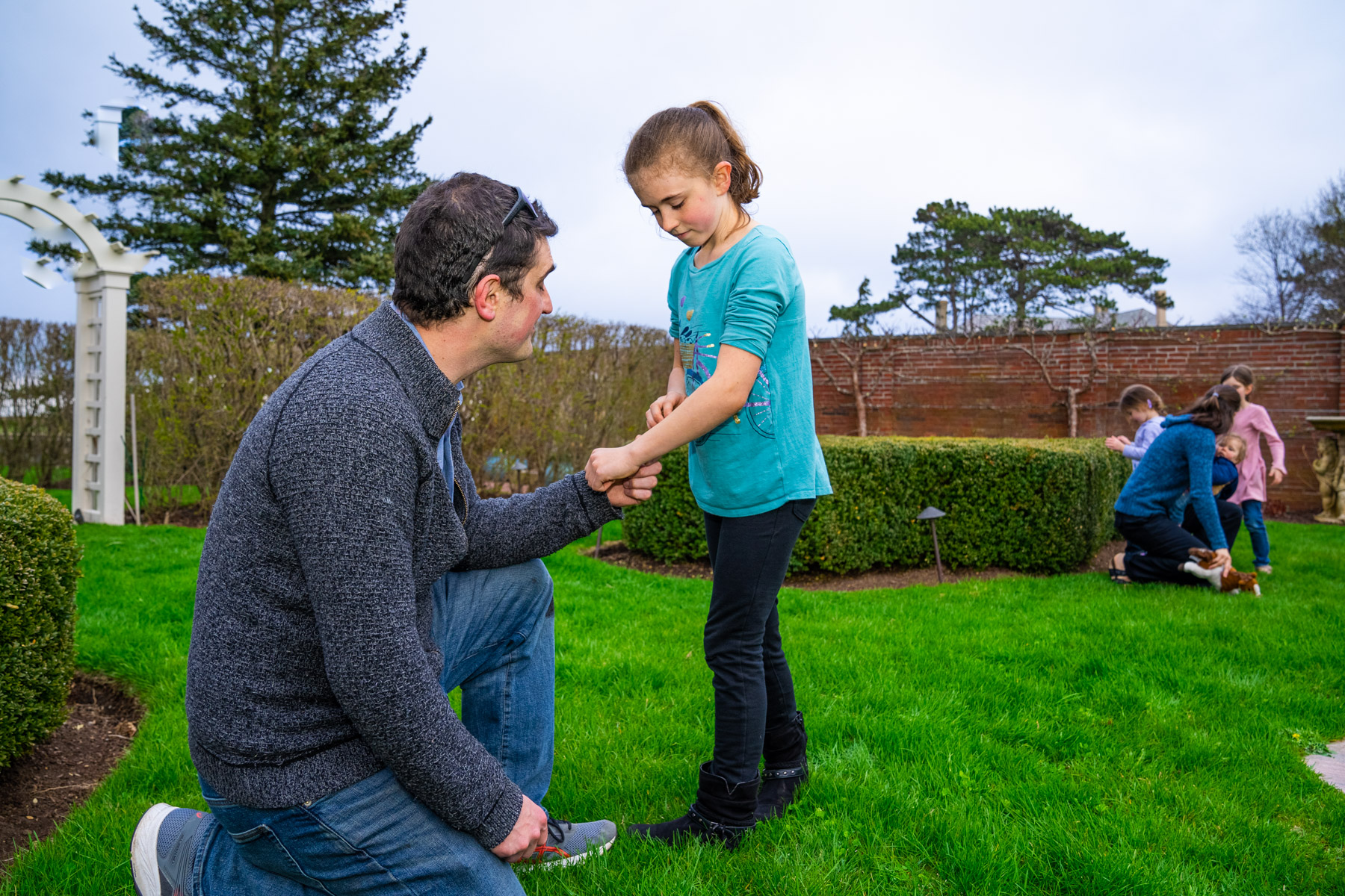 father looks at daughters arm for mosquito bites